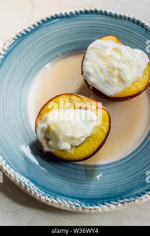 Pêches au four avec du yaourt grec et le miel / les nectarines. Dessert bio. Banque D'Images