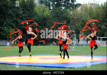 Groupe de petits filles faisant des exercices de gymnastique artistique avec des rubans sur un terrain de football. 20 juin 2019.Kiev, Ukraine Banque D'Images