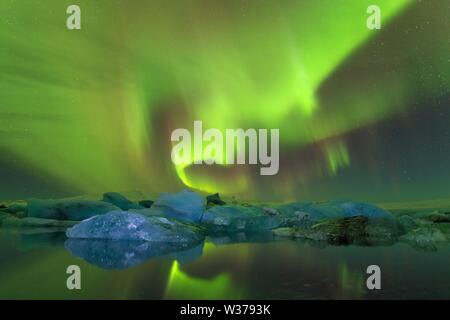 Aurora borealis au-dessus de la mer. Lagon du glacier de Jokulsarlon, Islande. Feux verts du nord. Ciel étoilé avec lumières polaires. Nuit paysage d'hiver Banque D'Images