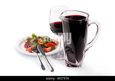 Pichet de vin rouge et de la salade de laitue, tomates et concombres dans une assiette, isolé sur fond blanc Banque D'Images