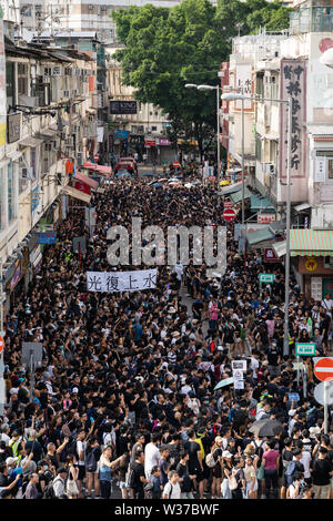 Des milliers de manifestants sont descendus dans la rue du quartier Sheung Shui dans le nord de Hong Kong dans un commerce parallèle de mars. Des manifestants se sont affrontés avec la police après le mois de mars. Nombre de manifestants sont blessés. Banque D'Images