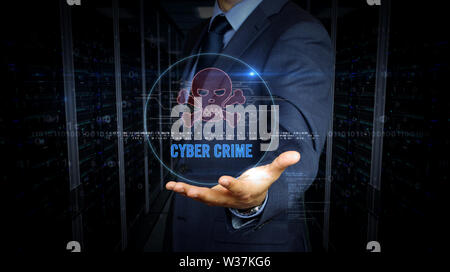 Un homme en costume et l'écran avec le symbole du crâne pirate hologramme. L'homme en utilisant l'interface d'affichage virtuel. Cyber-attaque, le crime en ligne, le vol et la fraude Banque D'Images