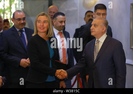 Bagdad, Iraq. Le 13 juillet, 2019. Responsable de la politique étrangère de l'Union européenne Federica Mogherini (L), serre la main du Ministre iraquien des affaires étrangères, Mohamed Alhakim avant leur réunion. Ameer Al Mohammedaw : Crédit/dpa/Alamy Live News Banque D'Images