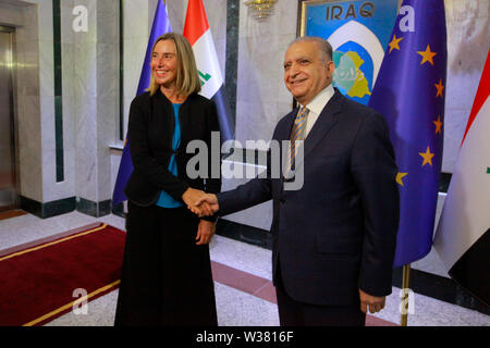 Bagdad, Iraq. Le 13 juillet, 2019. Responsable de la politique étrangère de l'Union européenne Federica Mogherini (L), serre la main du Ministre iraquien des affaires étrangères, Mohamed Alhakim avant leur réunion. Ameer Al Mohammedaw : Crédit/dpa/Alamy Live News Banque D'Images