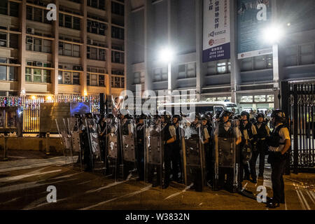 La police antiémeutes montent la garde sur la route après avoir affronté les manifestants.Des milliers de manifestants ont participé à la protestation contre le commerce parallèle à Sheung Shui district. Banque D'Images