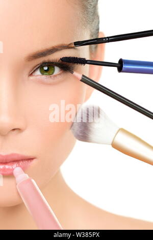 Transformation beauté maquillage visage - concept relooking femme asiatique avec de nombreux pinceaux contre un côté du visage putting mascara, blush et gloss Banque D'Images