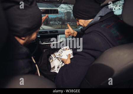 Après le succès du vol de banque, les voleurs sont dans la voiture montrant outre de leur argent et de célébrer la victoire sur le droit qu'ils avaient. Banque D'Images