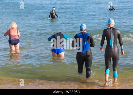 Bournemouth, Dorset, UK. Le 13 juillet, 2019. Pier à Pier sunset nager où les nageurs brave la Manche piscine à partir de Bournemouth à 1.4 km Boscombe piers dans défi de l'eau ouverte, la levée de fonds pour la fondation du Cœur, la BHF. Le premier coucher du soleil baigner à Bournemouth où les nageurs ont 2 heures pour terminer l'nager puis vous détendre sur la plage pour profiter du coucher du soleil, devant deux autres Pier à Pier nage qui doit avoir lieu demain au cours de la journée - des milliers de marcheurs dans les trois périodes. Une belle soirée pour l'ensoleillé chaud nager. Credit : Carolyn Jenkins/Alamy Live News Banque D'Images