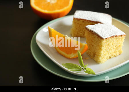 La cuisine italienne. Gros plan du gâteau carnaval de Florence avec orange sur fond sombre.lily Florentin sur le gâteau saupoudré de poudre de cacao. Banque D'Images