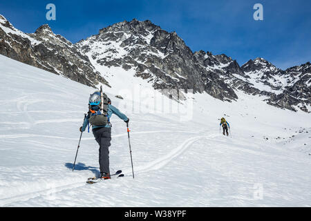 Deux skieurs de l'écorcher montée sur une pente près de l'ancien site minier de Snowbird. Ils sont dans le secteur du col de l'éclosoir Talkeetna Mountains de l'Alaska. Ski Banque D'Images