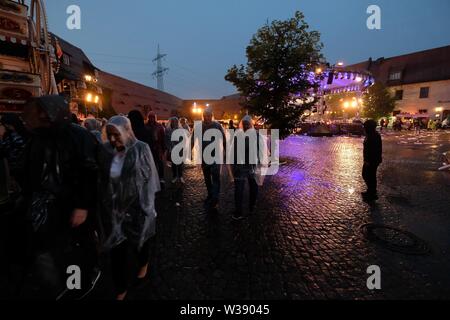 Chemnitz, Allemagne. Le 13 juillet, 2019. Les visiteurs de l'open-air show MDR 'Die Schlager des Sommers quittent le terrain de Klaffenbach Château. En raison de violents orages l'enregistrement a dû être arrêté. Credit : Sebastian Willnow/dpa-Zentralbild/dpa/Alamy Live News Banque D'Images