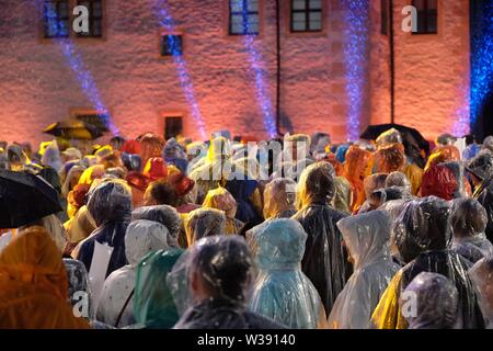 Chemnitz, Allemagne. Le 13 juillet, 2019. Les visiteurs de l'open-air show MDR 'Die Schlager des Sommers sont debout dans la cour intérieure du château Klaffenbach. En raison d'un violent orage l'enregistrement a dû être interrompu. Credit : Sebastian Willnow/dpa-Zentralbild/dpa/Alamy Live News Banque D'Images