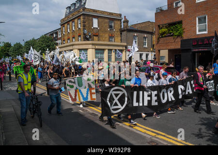 Londres, Royaume-Uni. 13 juillet 2019. Rébellion d'extinction de mars à Londres Hackney Downs à travers champs Hackney central comme un rappel de l'action urgente est nécessaire pour éviter l'extinction à l'échelle mondiale. Avant le mois de mars il y avait un spectacle de danse et de méditation sur la catastrophe climatique à venir. Derrière la bannière principale clé Dan's Band a joué pour un enterrement traditionnel de la Nouvelle Orléans et a été suivi par des squelettes géants représentant des animaux déjà disparues ou menacées, un cercueil, des abeilles géantes, des gens avec des drapeaux et d'un groupe de samba. Peter Marshall/Alamy Live News Banque D'Images