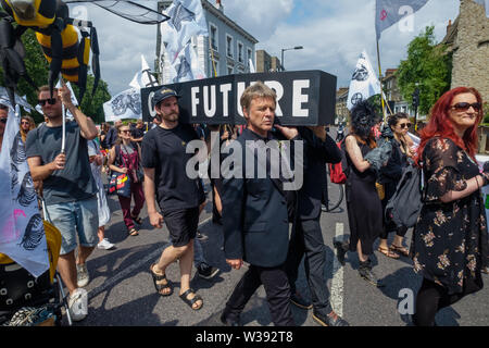 Londres, Royaume-Uni. 13 juillet 2019. Rébellion d'extinction de mars à Londres Hackney Downs à travers champs Hackney central comme un rappel de l'action urgente est nécessaire pour éviter l'extinction à l'échelle mondiale. Avant le mois de mars il y avait un spectacle de danse et de méditation sur la catastrophe climatique à venir. Derrière la bannière principale clé Dan's Band a joué pour un enterrement traditionnel de la Nouvelle Orléans et a été suivi par des squelettes géants représentant des animaux déjà disparues ou menacées, un cercueil, des abeilles géantes, des gens avec des drapeaux et d'un groupe de samba. Peter Marshall/Alamy Live News Banque D'Images