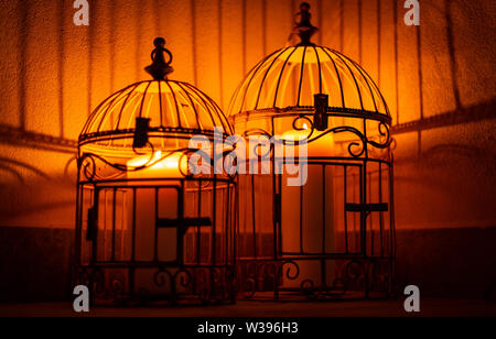 Chandelles en cage avec des ombres sur le mur Banque D'Images