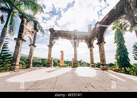 Belle jeune femme au palais aquatique Taman Ujung, Bali, Indonésie - Voyages blogger explorer Palais d'eau à Bali Banque D'Images