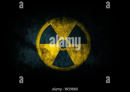 L'énergie nucléaire (rayonnements radioactifs rayonnement atomique) rond jaune forme de symbole peint sur la texture du mur de ciment béton massif fond sombre. Nucl Banque D'Images