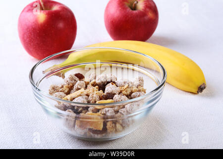 Une alimentation saine avec des flocons de maïs dans un bol de céréales, pomme, banane et le verre de lait. Le petit déjeuner du matin. Banque D'Images