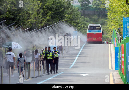 Gwangju, Corée du Sud. 14 juillet, 2019. Championnat du monde de natation : les spectateurs à pied sous un système de buée entre les sites de compétition. Crédit : Bernd Thissen/dpa/Alamy Live News Banque D'Images