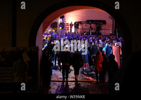 Chemnitz, Allemagne. Le 13 juillet, 2019. Les visiteurs sont debout dans la cour intérieure du château Klaffenbach. En raison d'un violent orage, le MDR-open air show 'Die Schlager des Sommers a dû être interrompu pendant un certain temps. Sur la radiodiffusion télévision MDR est prévue pour le 10 août. Credit : Sebastian Willnow/dpa-Zentralbild/dpa/Alamy Live News Banque D'Images