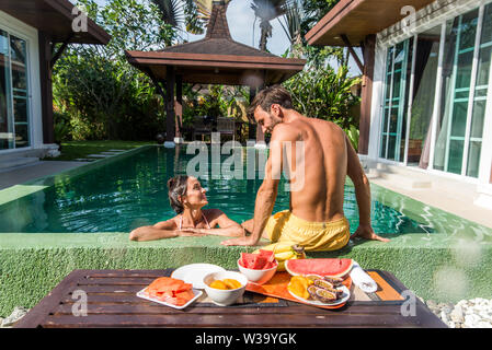 Couple d'amoureux dans une belle villa avec piscine dans un climat tropical, l'emplacement - les gens heureux sur les vacances d'été, des prescripteurs bénéficiant d'une lu Banque D'Images
