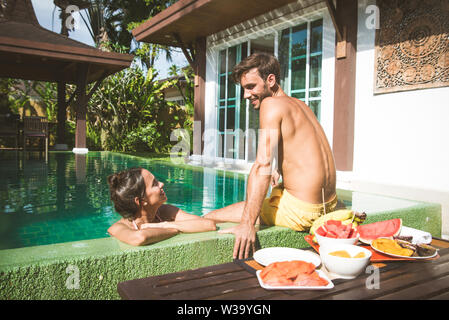 Couple d'amoureux dans une belle villa avec piscine dans un climat tropical, l'emplacement - les gens heureux sur les vacances d'été, des prescripteurs bénéficiant d'une lu Banque D'Images
