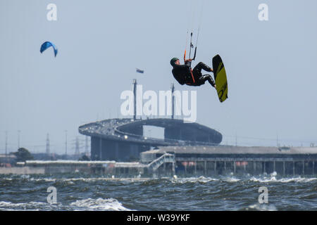 Le kitesurf sur un jour de vent à Port Phillip Bay Melbourne Australie avec West Gate Bridge en arrière-plan. Banque D'Images