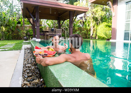 Couple d'amoureux dans une belle villa avec piscine dans un climat tropical, l'emplacement - les gens heureux sur les vacances d'été, des prescripteurs bénéficiant d'une lu Banque D'Images