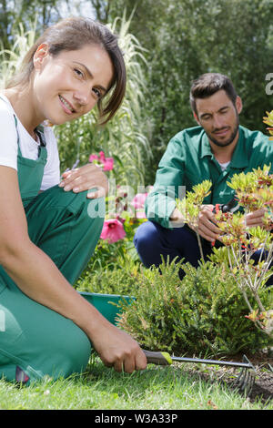 Exploitant agricole travaillant avec un râteau dans le jardin Banque D'Images