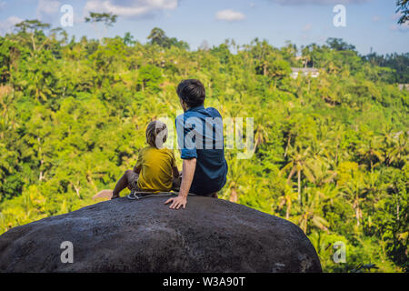 Père et fils les touristes sur une pierre sur la jungle. Concept de voyager avec des enfants. Que faire avec les enfants. Enfants bienvenus place Banque D'Images