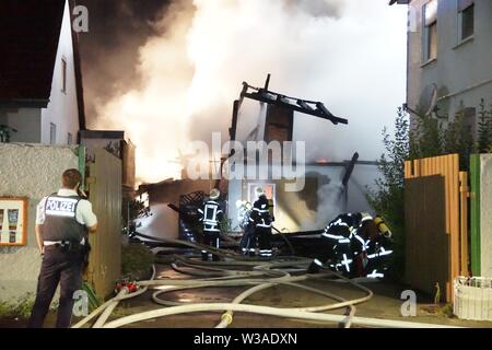 Goppingen, Allemagne. 14 juillet, 2019. Le service d'incendie s'éteint un immeuble en feu dans le centre-ville. Dans la nuit de dimanche plusieurs maisons ont été effacés à cause de l'incendie. L'incendie s'était déclaré pour des raisons inconnues dans l'immeuble inoccupé, la police a signalé. Par mesure de précaution, les gens du quartier ont été invités à quitter leurs foyers. Dpa : Crédit photo alliance/Alamy Live News Banque D'Images