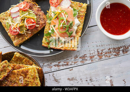 Crêpes aux courgettes et parmesan. Saumon fumé, fromage à la crème, les tomates cerises et les joints toriques de poivrons. L'avocat, fromage, salade de pommes de terre à rayures Banque D'Images