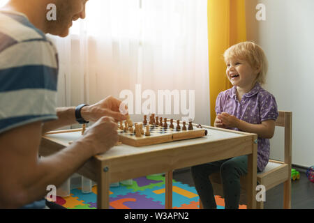 Père et fille de s'amuser ensemble apprendre à jouer aux échecs à la maison Banque D'Images