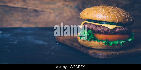 Home made Burger (cheeseburger) au boeuf et légumes sur un fond de bois. Classic Burger fait maison. Close up, copiez l'espace. Banque D'Images