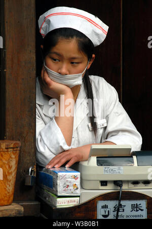 Ennuyer au caissier en étal de rue No 88 Jitai Wu, Sichuan en Chine. Femme chinoise à s'ennuyer. Emploi ennuyeux en Chine. Afin de s'ennuyer. No 88 jitai Wu Road, Chengdu, Chine Banque D'Images