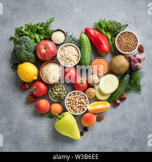 Arrière-plan de l'alimentation végétalienne Saine alimentation biologique - en forme de cœur à poser à plat, vue du dessus. Régime alimentaire sain de manger, nettoyer ou concept de désintoxication. Banque D'Images