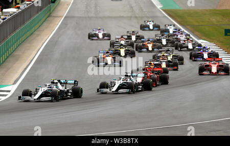 Les pilotes Mercedes Valtteri Bottas et Lewis Hamilton au premier virage pendant le Grand Prix de Grande-Bretagne à Silverstone, Towcester. Banque D'Images