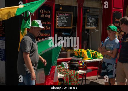 Vendeur de rue vendant des drapeaux Kerry et des souvenirs de groupes de mains lors d'un match à Killarney, comté de Kerry, Irlande. Banque D'Images