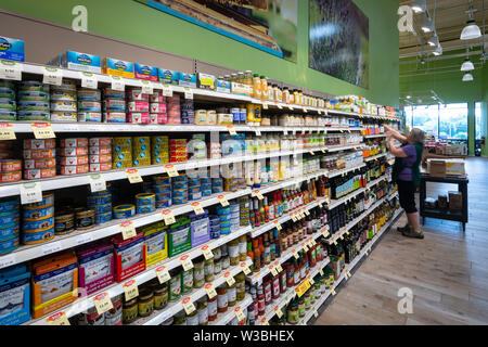 Femme employée dans les étagères de stockage Épicerie, USA Banque D'Images