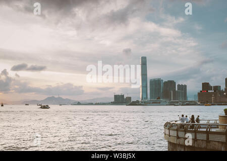 Les touristes négligé le Port Victoria de Hong Kong avec la vue de Tsim Sha Tsui. Banque D'Images