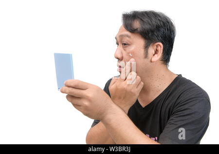 Homme asiatique d'âge moyen l'application de crème sur le visage avec le mélasma ou défaut et taches brunes de la peau ou de produit de beauté. concept. Banque D'Images