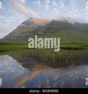 Le visage de la plupart de l'Ouest Buachaille Etive Mor reflète dans les eaux calmes de Lochan Na Fola sur une fin de soirée d'été Banque D'Images