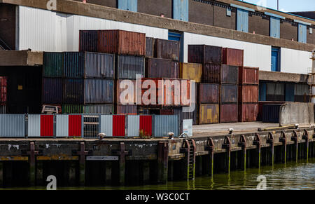 L'entreprise de logistique. Old rusty empilés conteneurs sur un vieux quai en bois, port international de Rotterdam, Pays-Bas, journée ensoleillée Banque D'Images