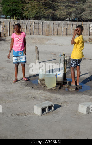 Deux filles collectant de l'eau, Mwandi, Zambie, Afrique. Banque D'Images