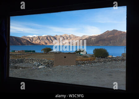 Pangong Tso (le lac Pangong) et ses environs vus à travers la fenêtre de l'un des restaurants de village Spangmik, Ladakh, Inde Banque D'Images