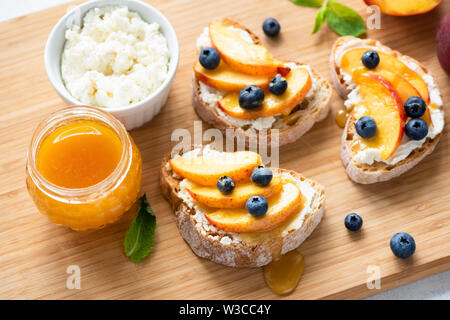 Apéritif bruschetta à la Ricotta Pêche et miel sur planche de bois. Pique-nique d'été ou de l'alimentation du démarreur Parti Banque D'Images