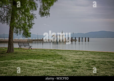 L'humeur du soir au lac Trasimeno. Vue sur le port et l'embarcadère du lac Trasimène dans le village de Castiglione del Lago en Ombrie, Italie. Banque D'Images