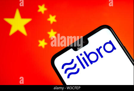 Facebook Balance devise crypto logo sur le smartphone et floues drapeau de la Chine à un écran d'ordinateur portable sur l'arrière-plan. Photo conceptuelle. Banque D'Images