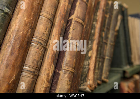 Vintage, livres anciens de poil sur la surface en bois dans des tons chauds de la lumière directionnelle. Focus sélectif. Banque D'Images