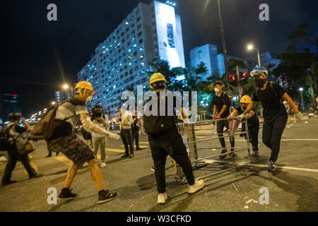 Utilisation manifestant road side barrières métalliques pour ralentir l'avance de police.Des milliers de manifestants pro démocratie descendent dans la rue une fois de plus dans une nouvelle vague de manifestations antigouvernementales qui ont suscité par le projet de loi sur l'extradition que le gouvernement de Hong Kong a essayé de le pousser vers l'avant en juin 2019.La police a fait au moins 30 manifestants se sont heurtés à des arrestations, alors que la police anti-émeute dans la soirée. Banque D'Images